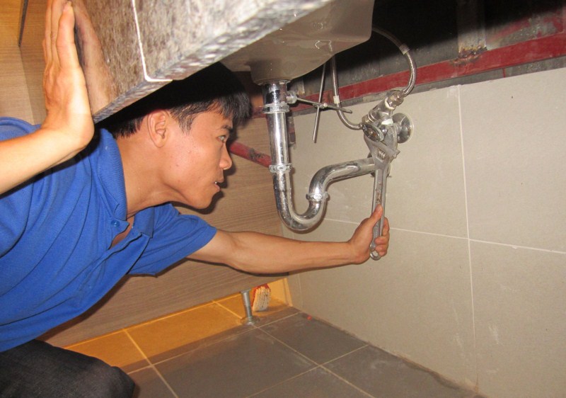Kỹ thuật viên kiểm tra cặn bẩn bên trong ống nước trước khi làm sạch